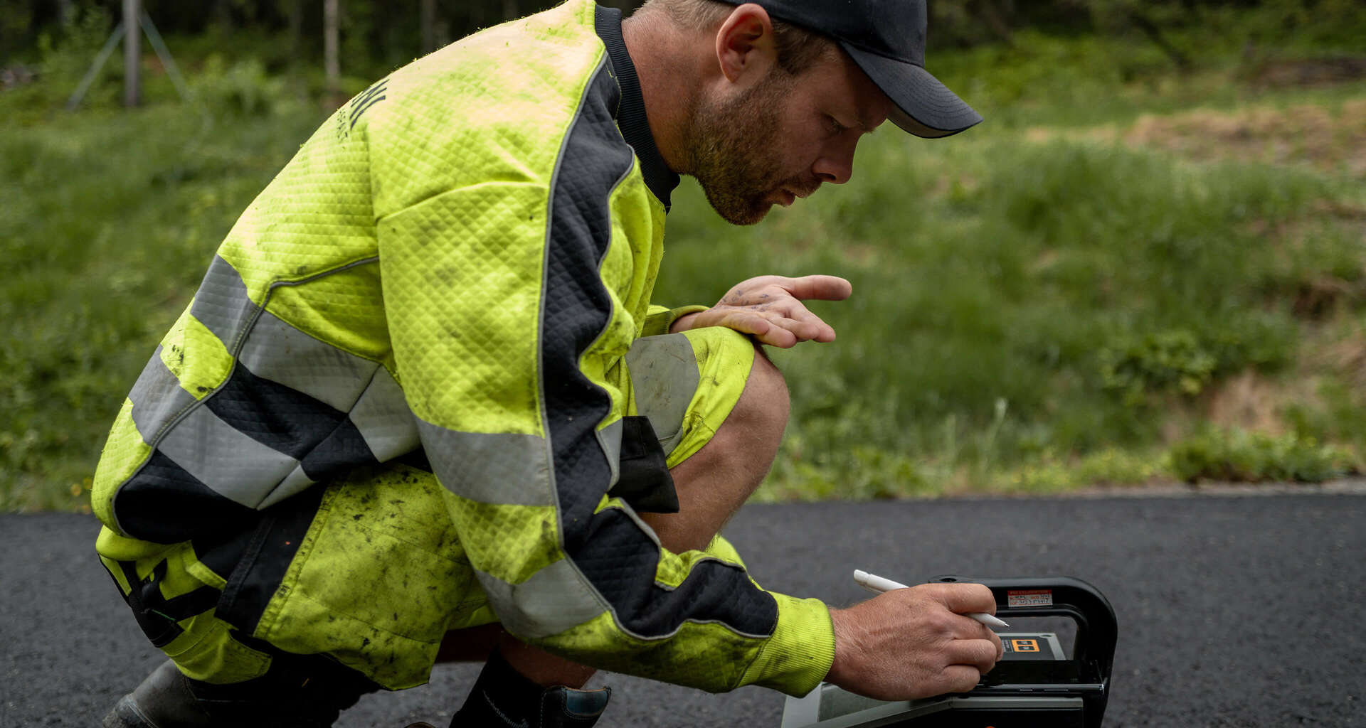 Ansatt hos Brani som gjør digitale målinger på nylagt asfalt. Foto